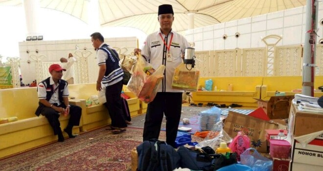 Petugas bandara saat mensweping barang bawaan jamaah haji di bandara.